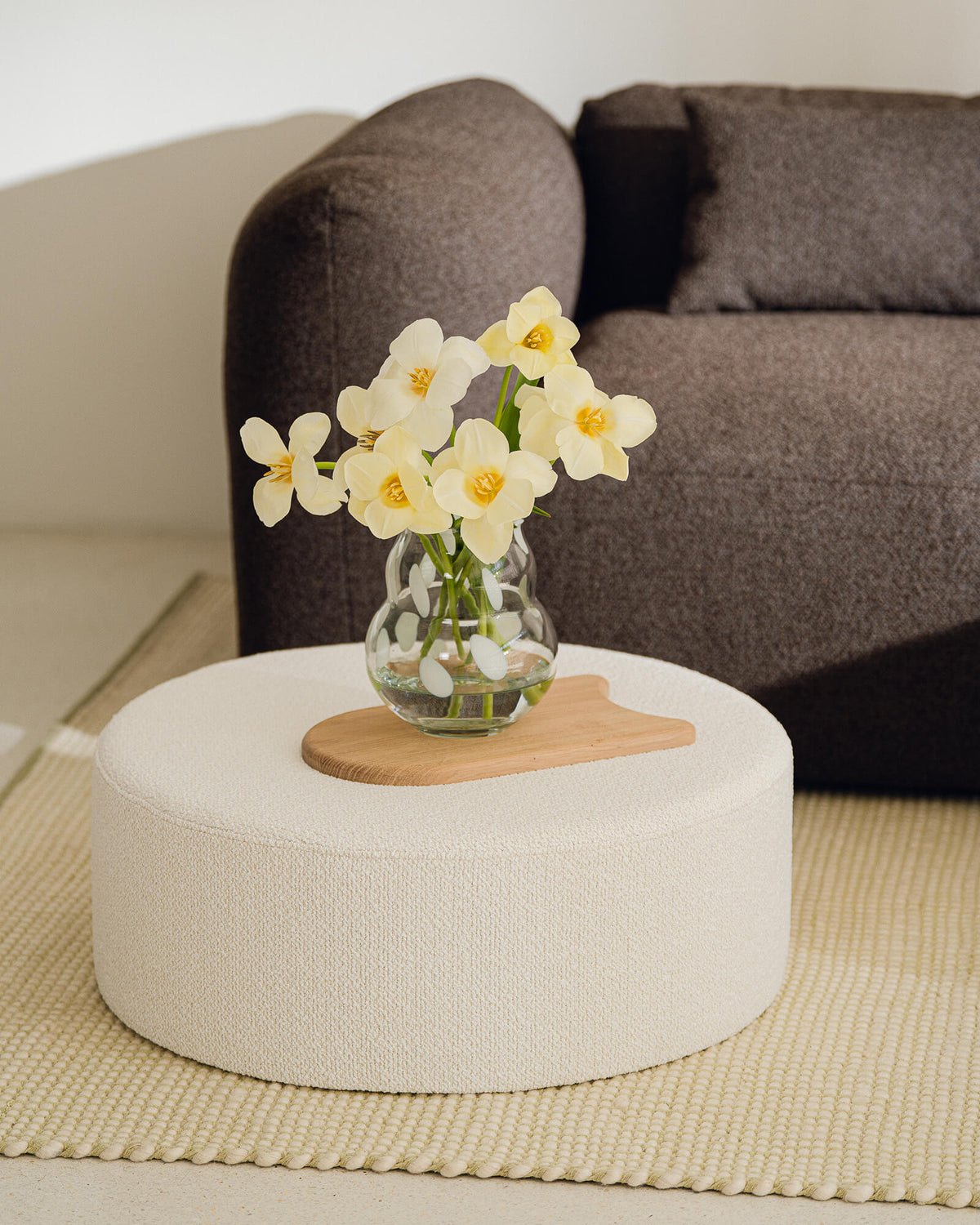 Beige pouf used as a low accent table with a decorative tray